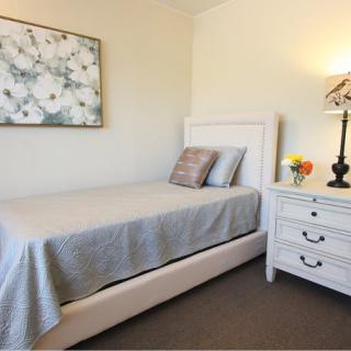 A cozy bedroom with a single bed, nightstand, and decorative elements.