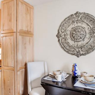 Cozy dining area with a decorative wall piece and neatly set table.