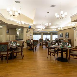 A well-lit dining area with neatly arranged tables and chairs in a restaurant setting.