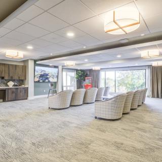 Spacious and modern living room with a comfortable seating area, large windows, and elegant ceiling lights.
