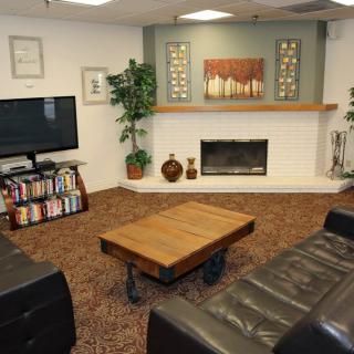 A cozy living room featuring a fireplace, television, and a comfortable seating area with decorative elements.