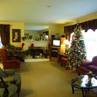 A cozy living room decorated for the holidays with a Christmas tree and stockings by the fireplace.