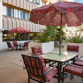 An outdoor patio area with tables and chairs under large umbrellas.