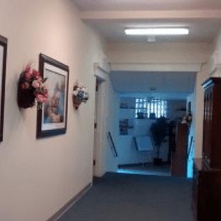 A hallway in an office setting, featuring artwork and subtle lighting.