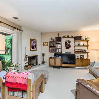 A cozy living room with retro decor featuring a television, fireplace, and comfortable seating.