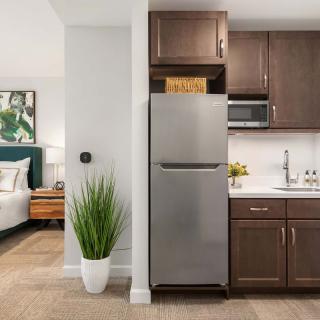A modern apartment interior with a compact kitchen and adjacent bedroom.