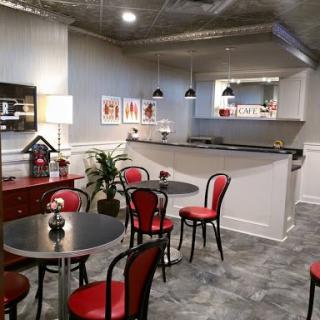 A stylish caf interior featuring red chairs, modern furniture, and contemporary wall art.