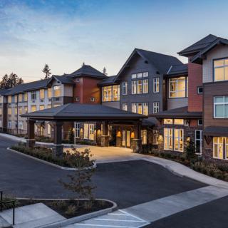 A modern residential building with a welcoming entrance and spacious parking area.