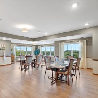 A spacious and inviting dining area featuring modern furnishings, large windows that allow ample natural light, and a cozy atmosphere for gatherings.