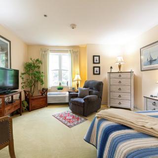 A cozy bedroom with comfortable seating, a TV, and decorative elements.