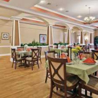 An elegant dining area with neatly arranged tables and chairs, featuring tasteful decor and a warm atmosphere.