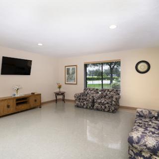 A spacious and well-lit living room featuring comfortable seating and a large window for natural light.