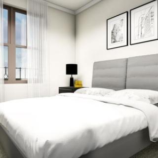 A modern, minimalist bedroom with white bedding and framed artwork on the walls.