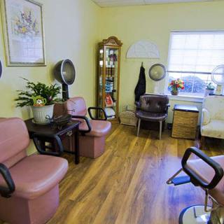 A cozy salon waiting area with chairs and hair drying stations.