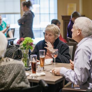 Seniors enjoying a meal and conversation at a social gathering.