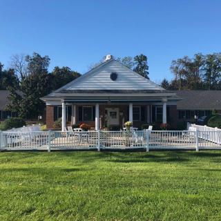 A residential house with a spacious lawn and fenced porch.