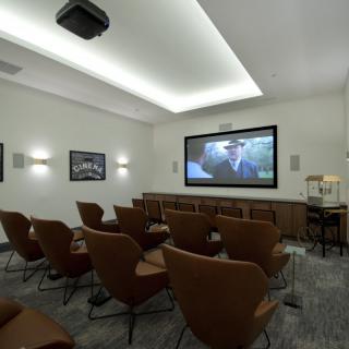 A cozy home theater setup with comfortable seating and a large projection screen.