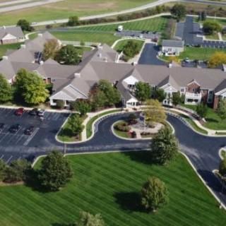 Aerial view of a complex surrounded by landscaped greenery and roads.
