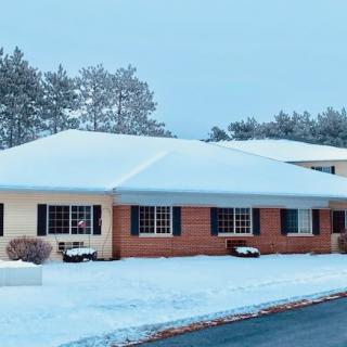 A snow-covered house in a winter landscape.