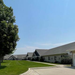 A peaceful suburban neighborhood with rows of houses, a well-maintained lawn, and a clear blue sky.