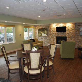 A cosy living room with a dining table and fireplace, featuring modern decor.