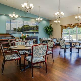A well-lit dining area with elegant chandeliers and comfortable seating.