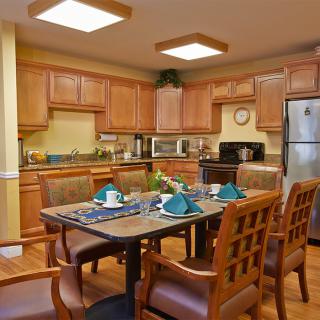 A cozy kitchen and dining area with wood cabinets and a neatly set table.