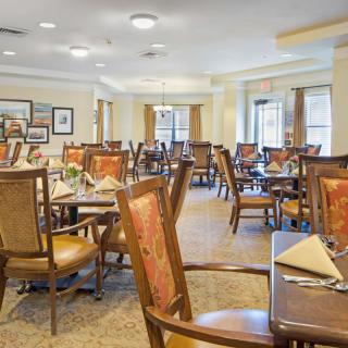 An elegantly set dining room with neatly arranged tables and chairs, ready for guests.