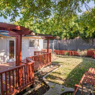 A cozy backyard with a wooden deck and lush greenery.