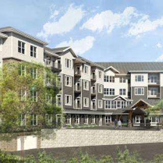 A modern residential building featuring multiple levels with contemporary architecture and landscaped surroundings.