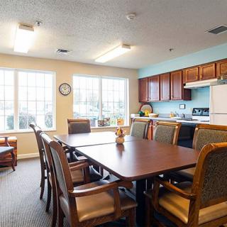 A cozy dining area with a table and chairs adjacent to a kitchen.