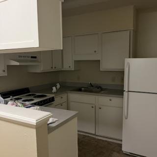 A clean and modern kitchen featuring white cabinetry and essential appliances.