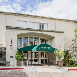 The exterior entrance of a residential building with a green awning.