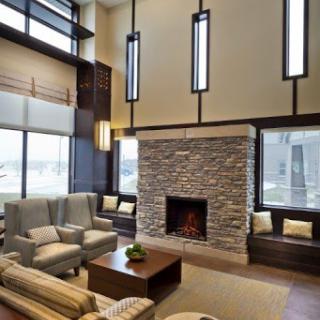 A modern and inviting living room featuring a cozy fireplace and ample natural light.