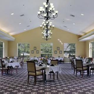 Elegant dining room with chandeliers and neatly arranged tables.