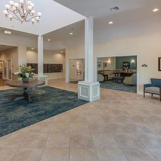 Spacious lobby with elegant chandelier and seating area.