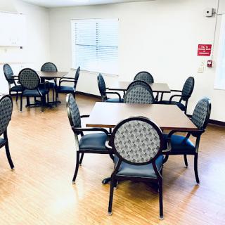 A spacious dining area featuring multiple tables and chairs, designed for casual gatherings.