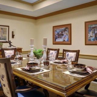 A well-appointed dining room with an elegant table setting and framed artwork on the walls.