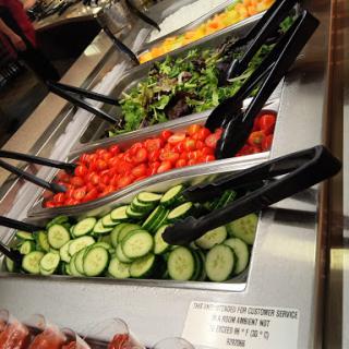 A colorful display of fresh vegetables at a salad bar.