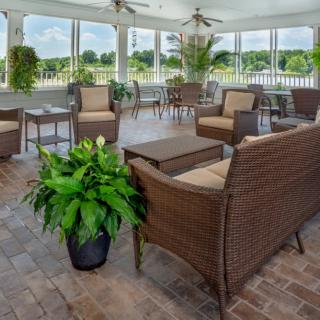 A cozy outdoor patio area featuring wicker furniture and lush greenery.