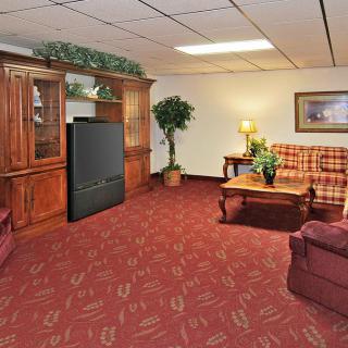 A cozy living room with a plaid sofa, wooden furniture, and a television.