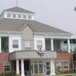A two-story building with a porch and flag decoration.