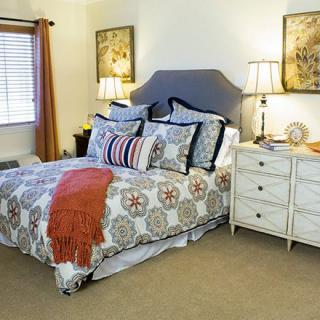 A cozy bedroom with a decorative bed, pillows, and bedside lamps.