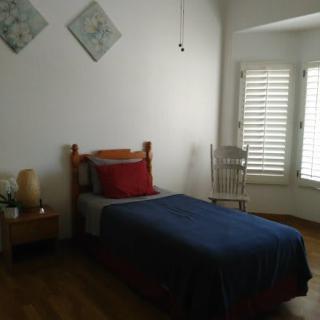A minimalist bedroom with a single bed and natural lighting.