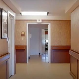 A hospital hallway with doors and bright lighting.
