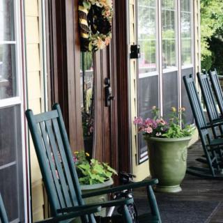 A cozy porch with rocking chairs and potted plants.