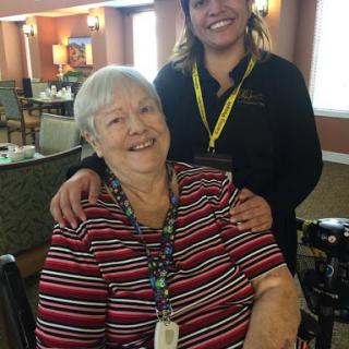 A joyful moment shared between a caregiver and a resident in an assisted living community.