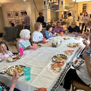 A cheerful gathering of seniors enjoying a meal together at a community dining event.