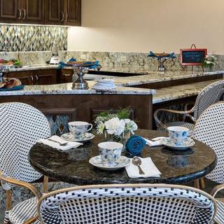 A cozy cafe table setting with teacups and chairs.