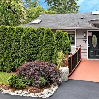 A cozy house with a well-maintained front yard featuring lush greenery and a paved driveway.